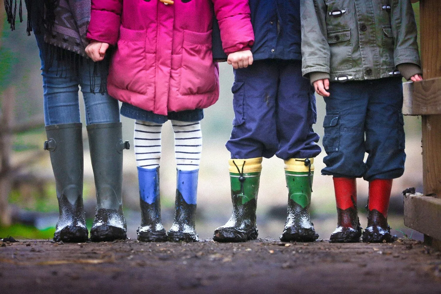 Children participating in a speech therapy session for grammar, wearing rain boots outside
