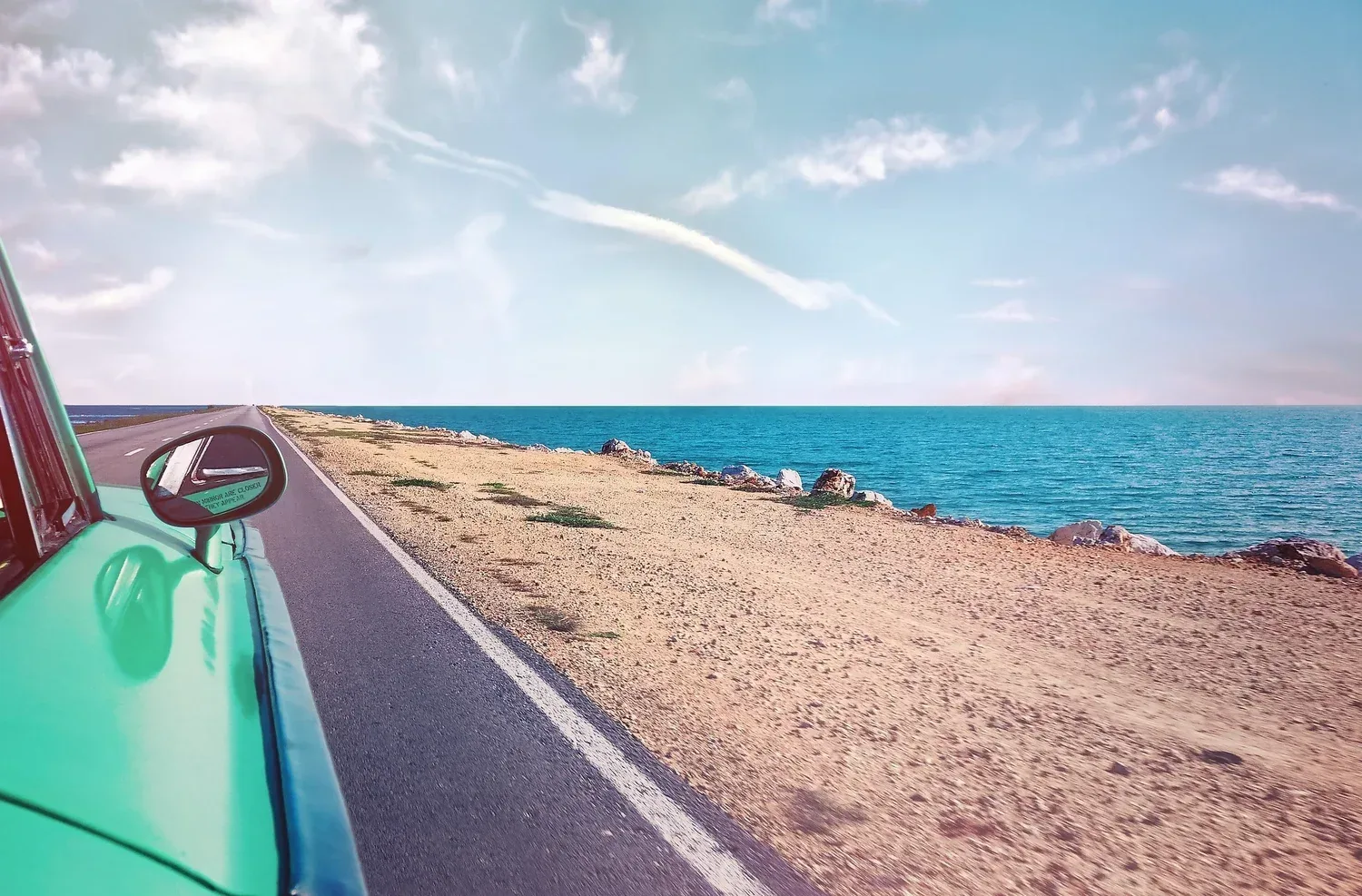 Car driving down the coast in someone's imagination of their dream vacation