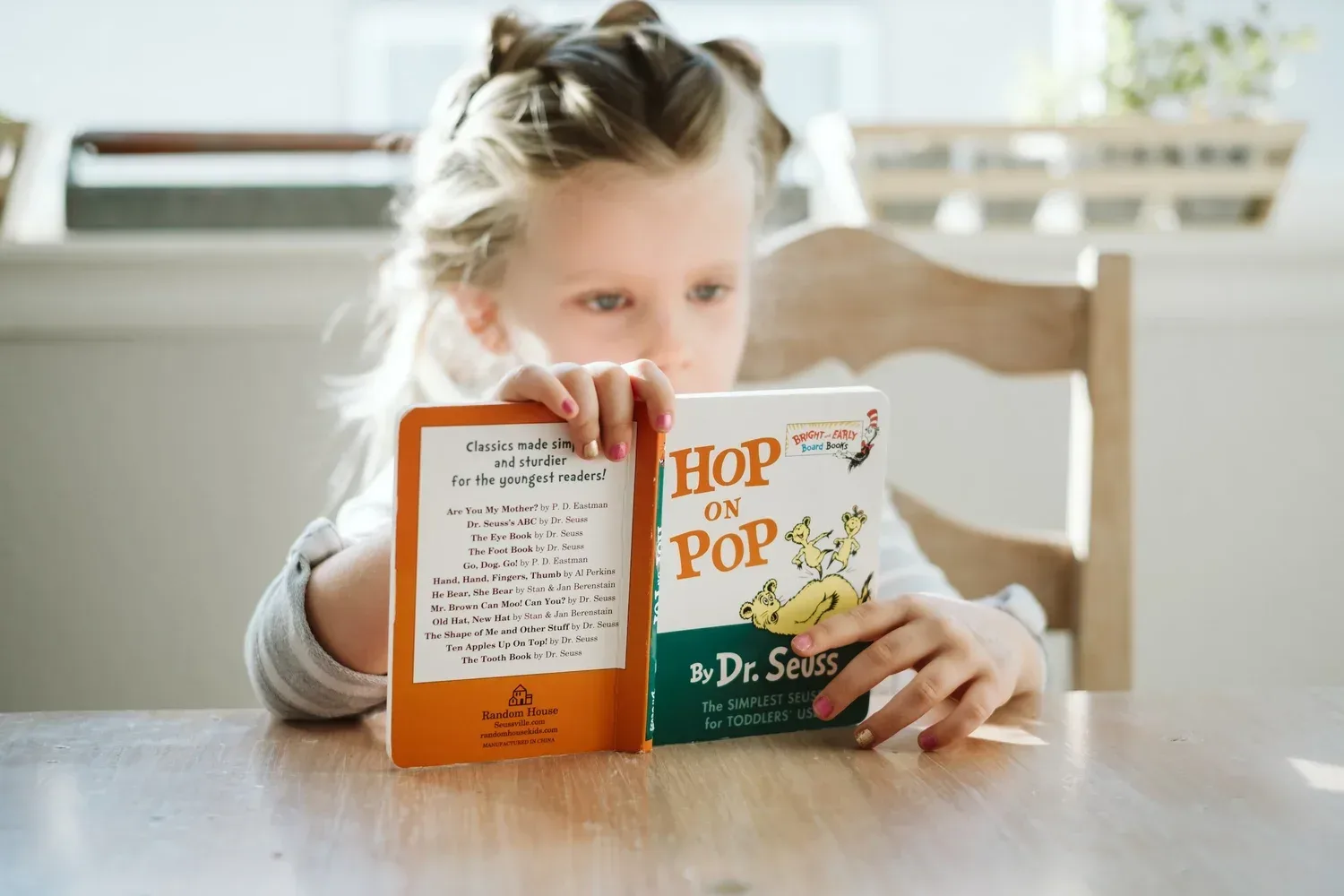 Student reading a Dr. Seuss book during her at home speech therapy session in Sorrento Valley CA