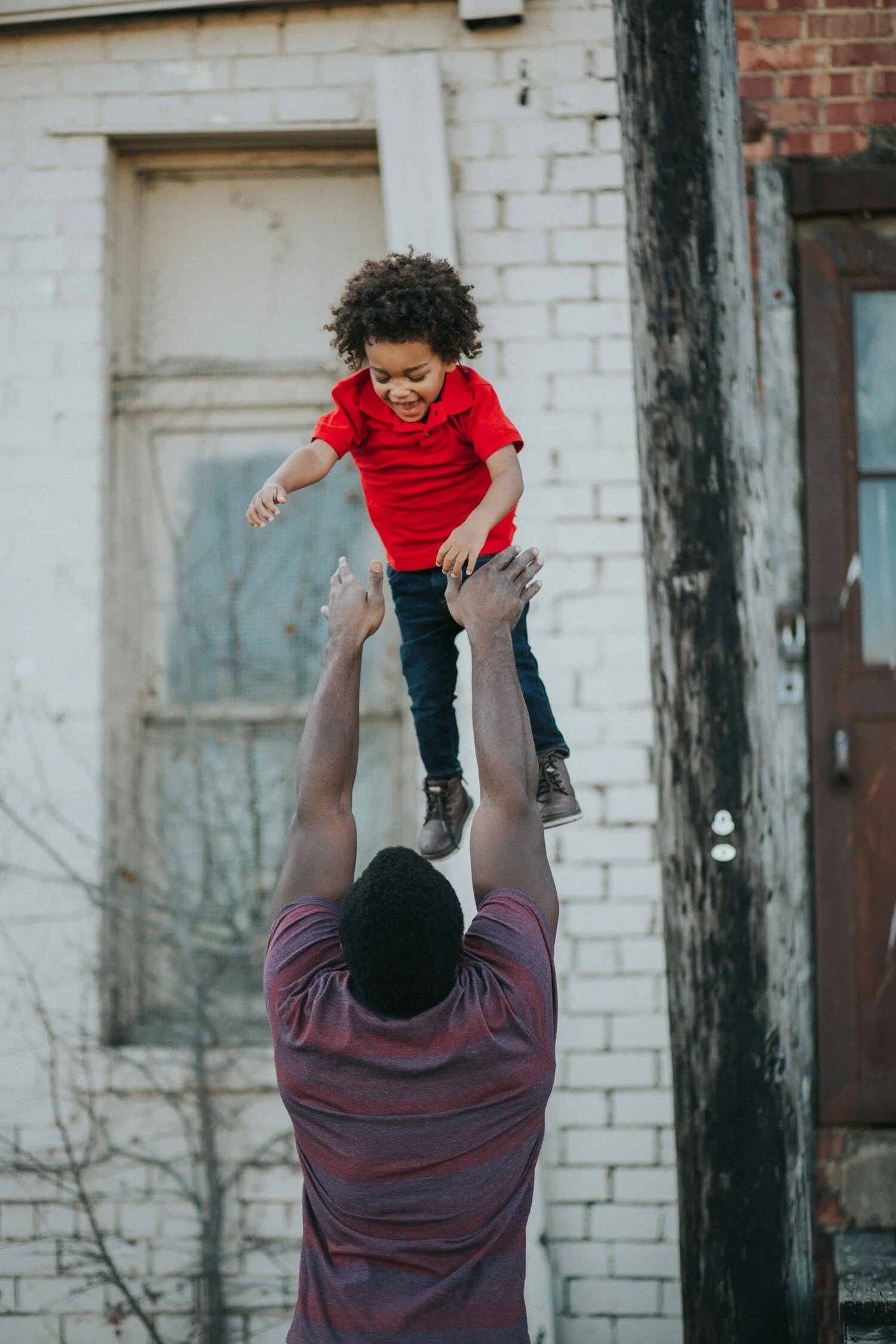 Father throwing his son in the air while the son smiles