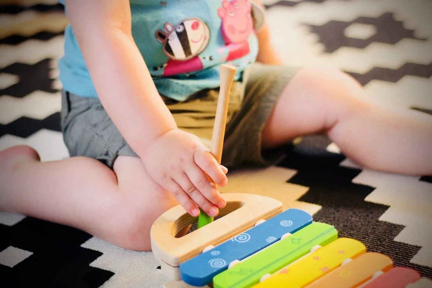 Two year old playing with an instrument at home to learn speech in Carmel Valley San Diego