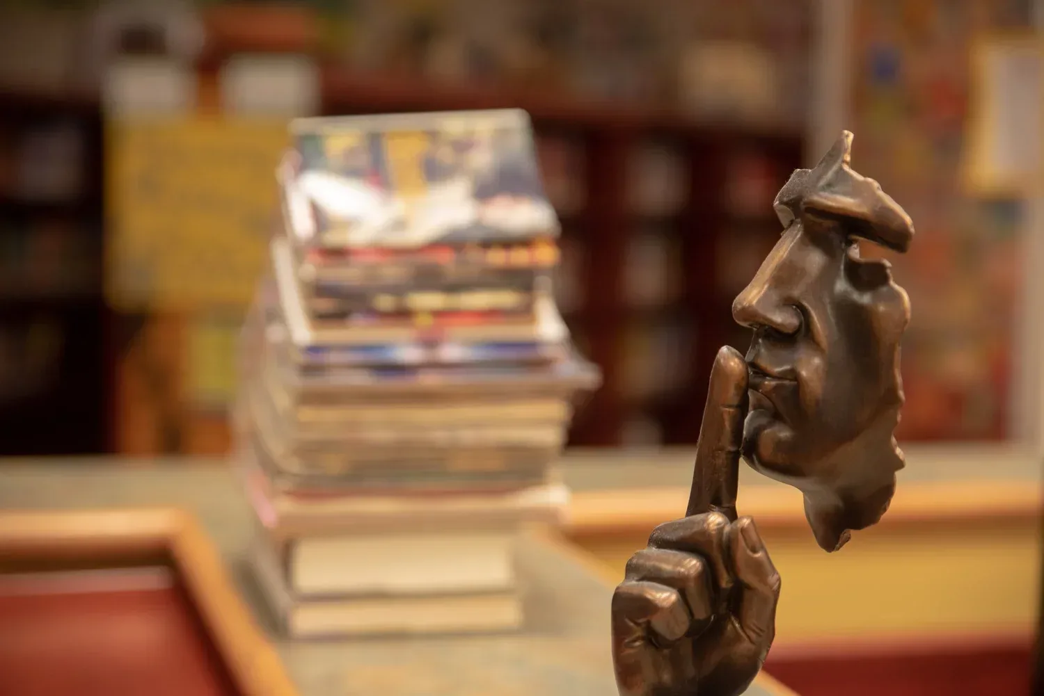 Sculpture of a man being quiet in a library to show pausing during conversation while speaking with your child to expand their vocabulary