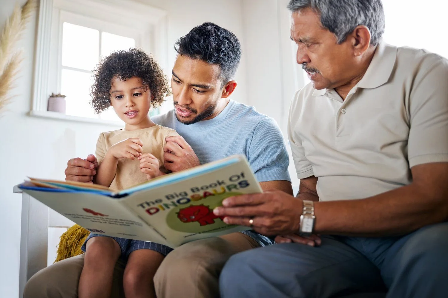 Dad and grandpa reading to a child at home to improve speech