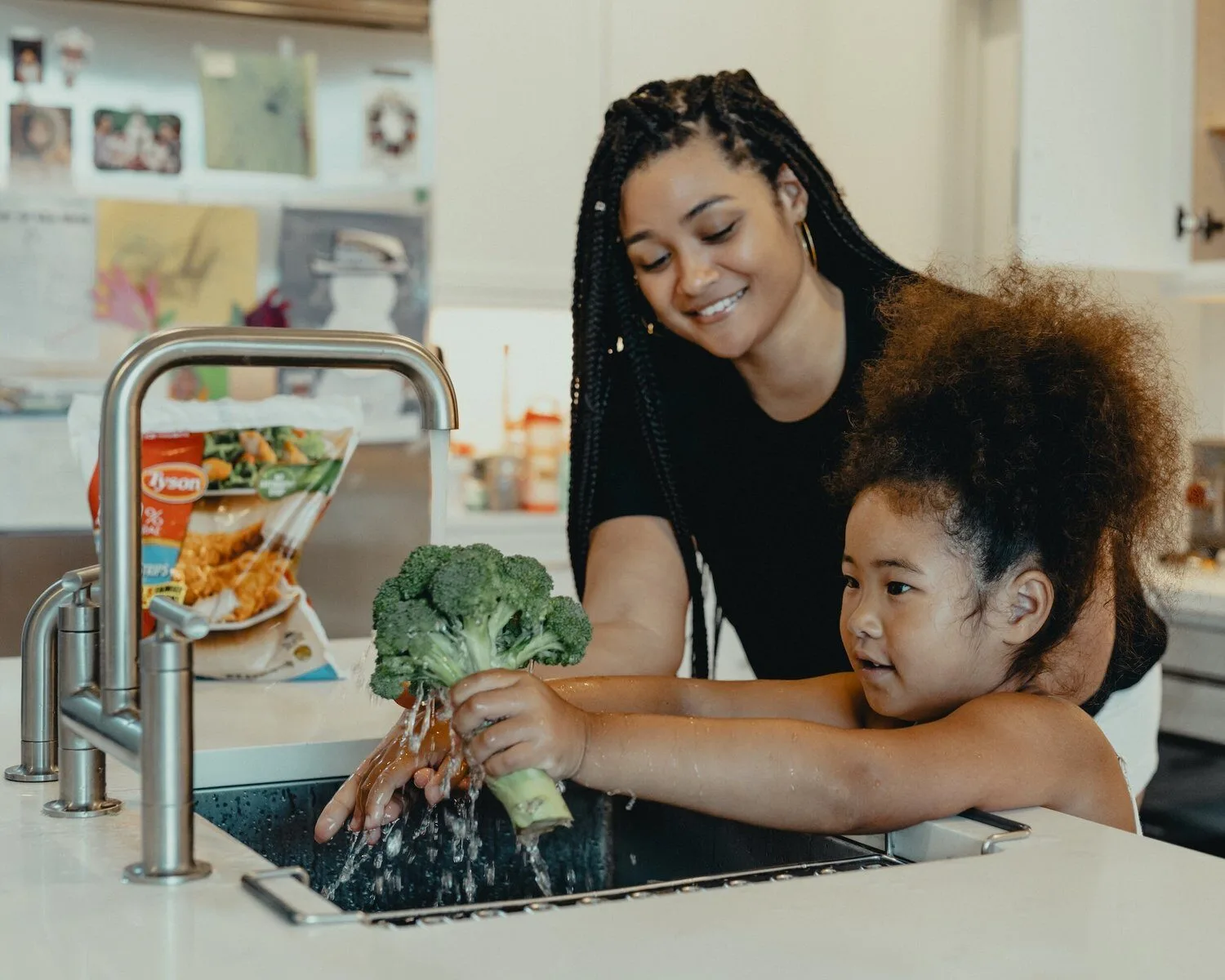 Mom washing broccoli with her 3 year old to increase vocabulary at home