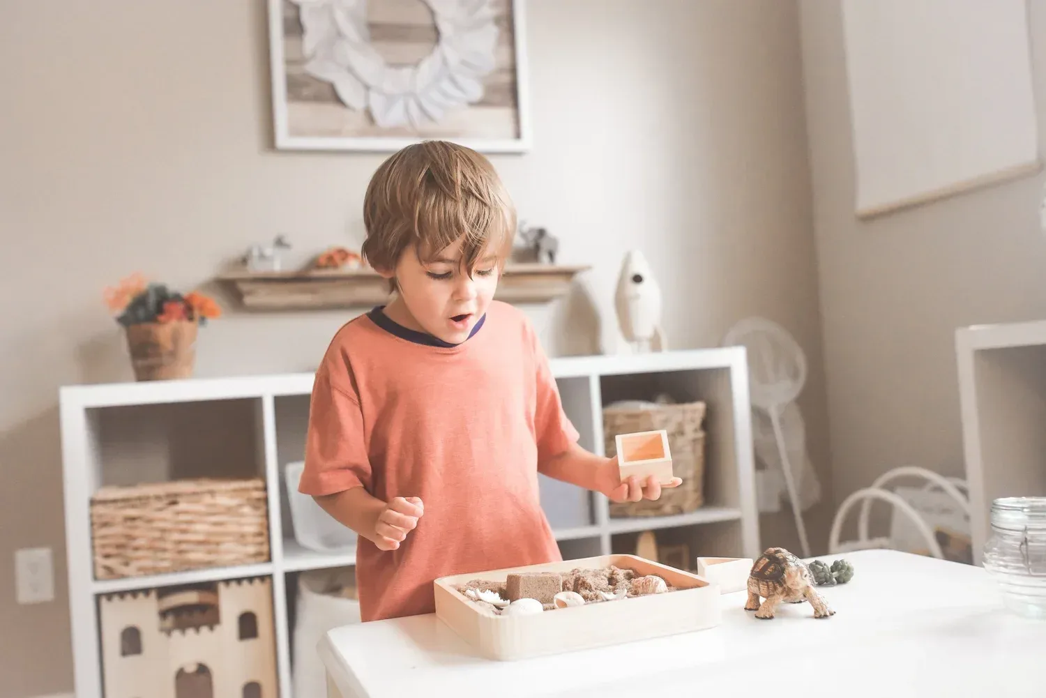 Three year old playing with sand and blocks to use sound effects in speech therapy at home